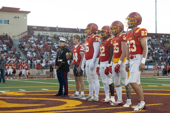 U.S. Marine Corps Sgt. Andrew Cortez, a canvassing recruiter with Recruiting Station Sacramento, stands with the Jesuit High School football captains during a Great American Rivalry Series game at Hughes Stadium in Sacramento, California, Sept. 14, 2024. The Great American Rivalry Series shines the spotlight on top high school football rivalries across the nation, where long-standing traditions are valued, expectations are sky high, and followers are passionate and loyal. (U.S. Marine Corps photo by Staff Sgt. Ryan Harvey)