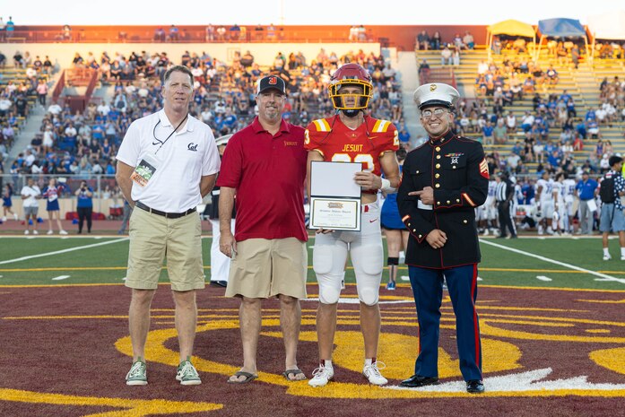 U.S. Marine Corps Sgt. Andrew Cortez, a canvassing recruiter with Recruiting Station Sacramento, stands with the Jesuit High School scholar athlete during a Great American Rivalry Series game at Hughes Stadium in Sacramento, California, Sept. 14, 2024. The Great American Rivalry Series shines the spotlight on top high school football rivalries across the nation, where long-standing traditions are valued, expectations are sky high, and followers are passionate and loyal. (U.S. Marine Corps photo by Staff Sgt. Ryan Harvey)