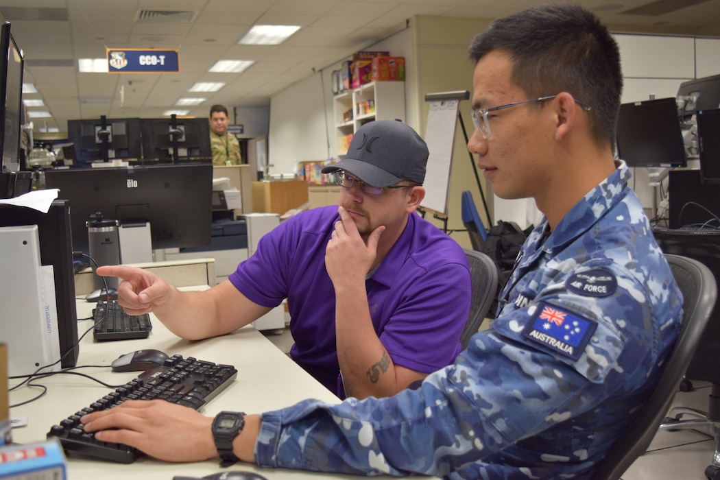 uniformed coalition member working at computer