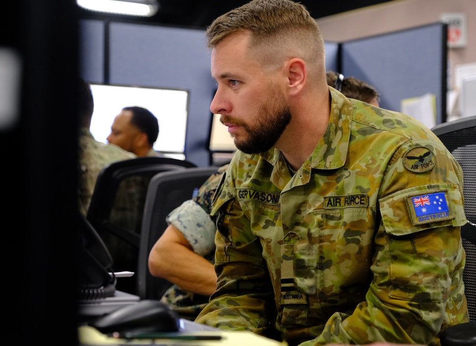 a uniformed Royal Australian Air Force member works at a computer