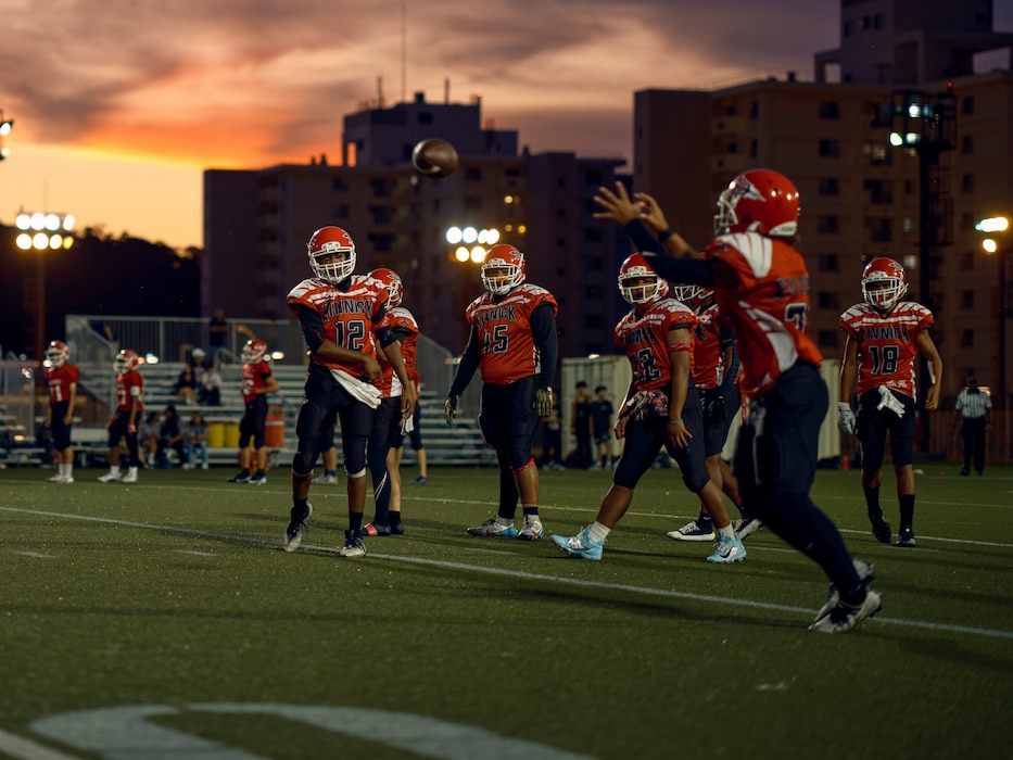 A Nile C. Kinnick High School Red Devils warm up for the school's homecoming game September 13, 2024. Kinnick defeated visiting Zama High School 35-7 in the homecoming game later in the evening.