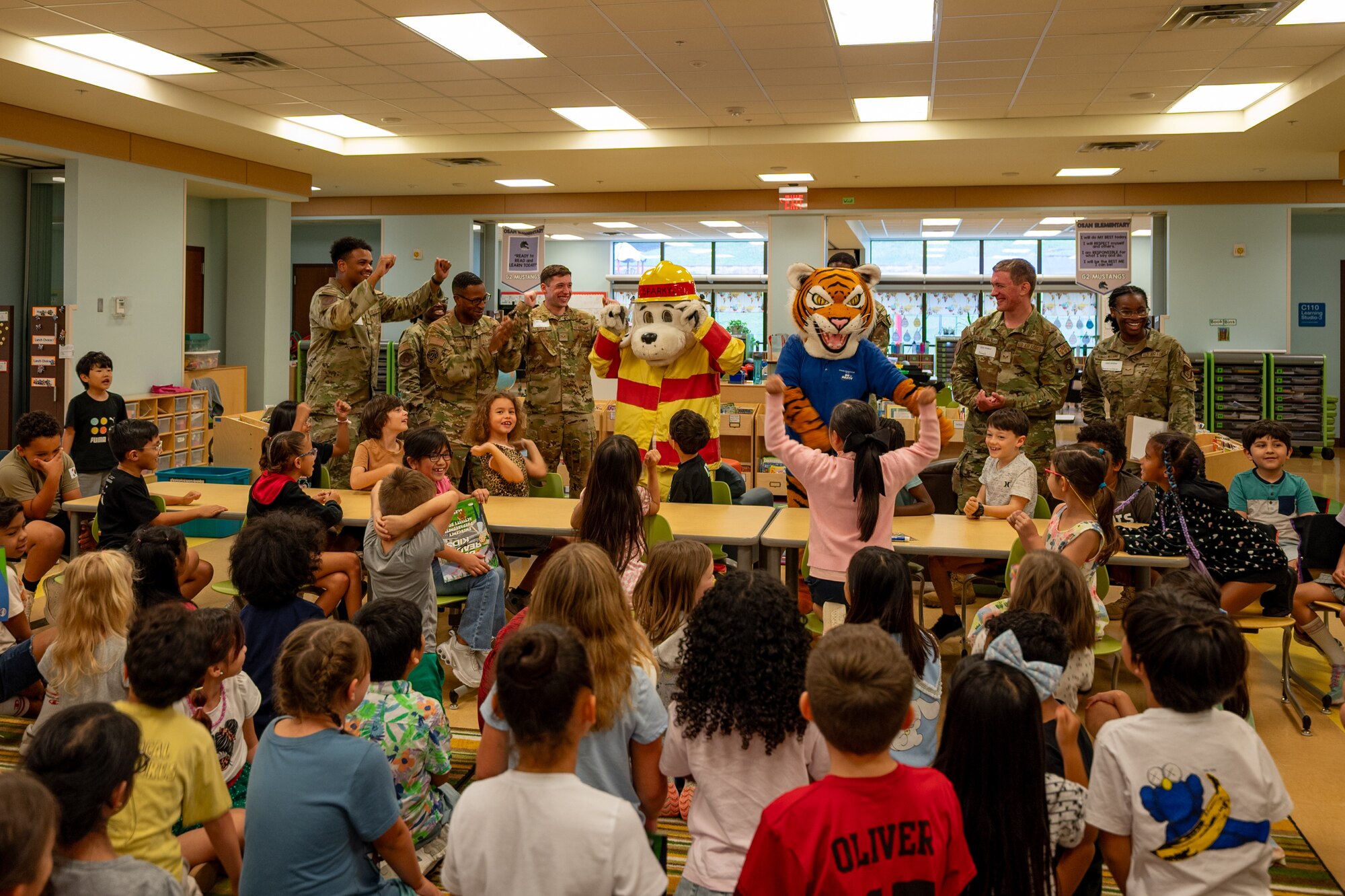Osan Elementary School students cheer for Sparky the Fire Dog and Cybil the Readiness Tiger at Osan Air Base, Republic of Korea, Sept. 18, 2024. U.S. Air Force Airmen assigned to the 51st Civil Engineer Squadron visited OES to provide students with a briefing on safety measures and preparedness for natural disasters. The 51st Fighter Wing is dedicated to building a safer community by educating young students on emergency preparedness, ensuring they are well-informed and ready to handle unexpected situations. (U.S. Air Force photo by Senior Airman Brittany Russell)