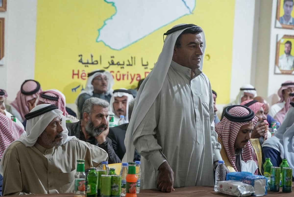 A Middle Eastern man speaks at community event.