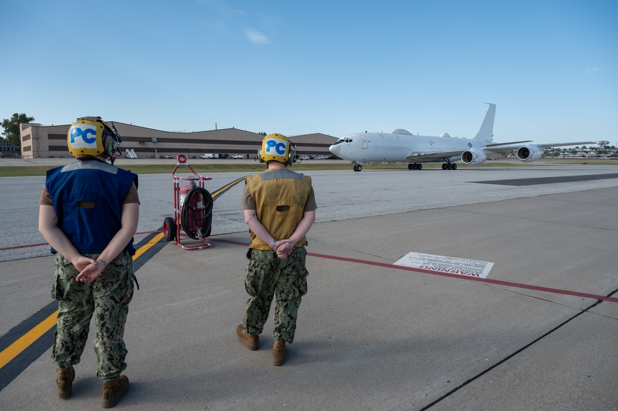 Sailors wait for an E-6B Mercury to taxi