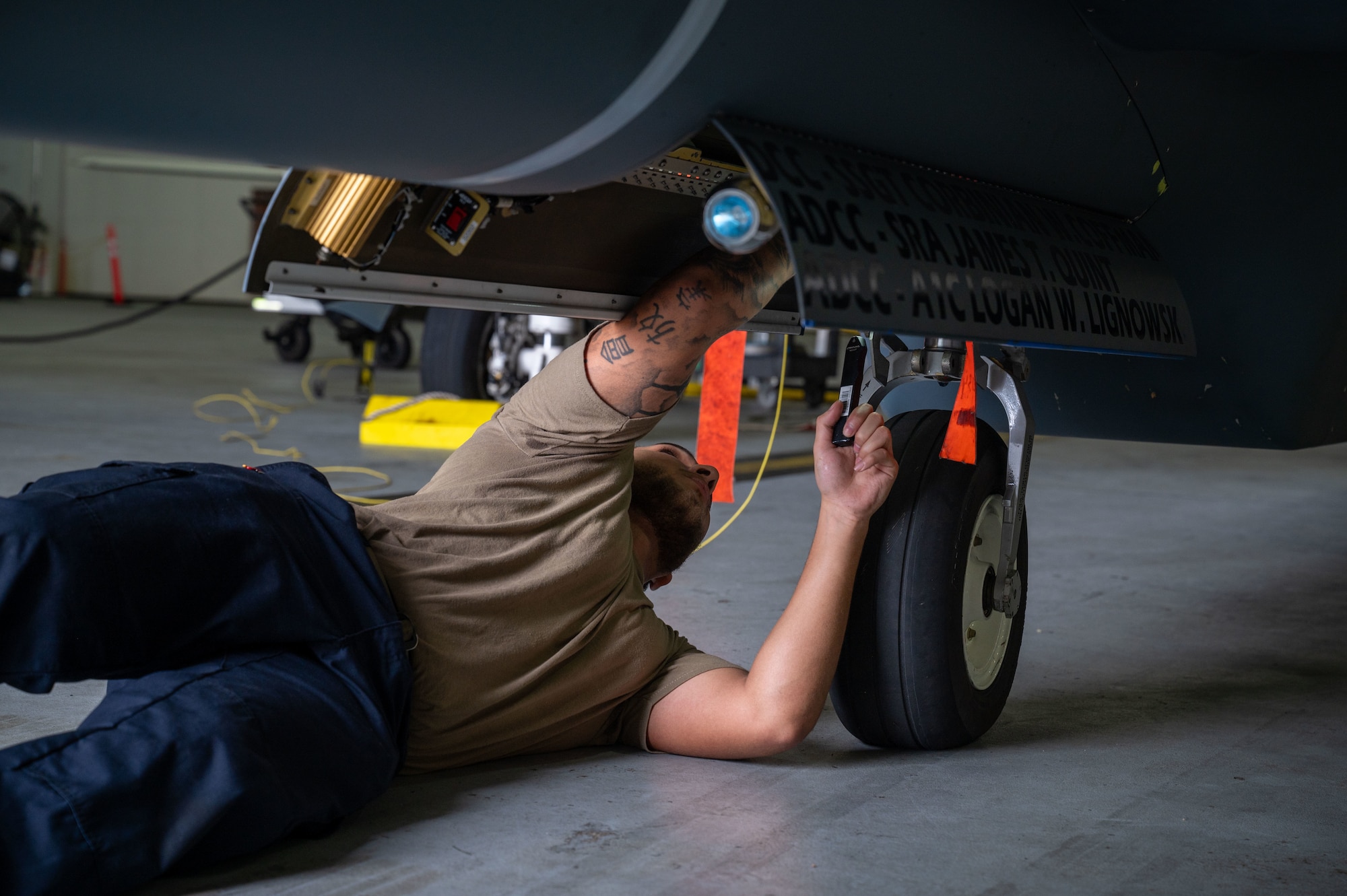 U.S. Air Force Airman 1st Class Benjamin Dallas, 4th Reconnaissance Squadron RQ-4B Global Hawk Crew Chief, inspects the nose landing gear assembly during Preflight inspection on an RQ-4B on Andersen Air Force Base, Guam, Sept. 16, 2024. The RQ-4B is constantly checked before and after each flight, with several members performing routine maintenance checks to ensure capability and safety.  (U.S. Air Force Airman 1st Class Manasseh Demissie)