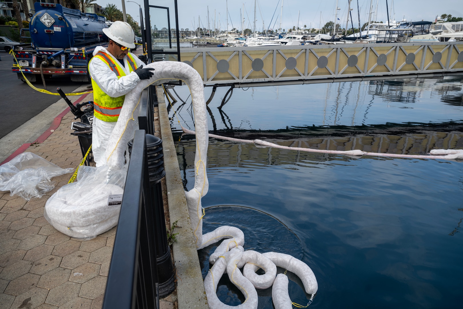 A man tends sorbent boom at the site of a sunken vessel leaking diesel fuel