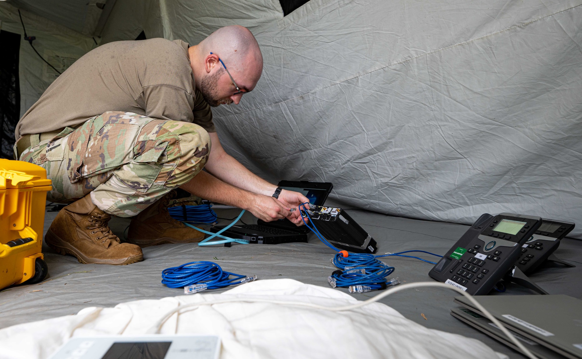 U.S. Air Force Airman 1st Class Cody McGuire, 18th Communications Squadrons enterprise technician, uses a fly away kit to set up phone lines during an agile combat employment exercise, Shogun Shield, at Kadena Air Base, Japan, Sept. 18, 2024.
