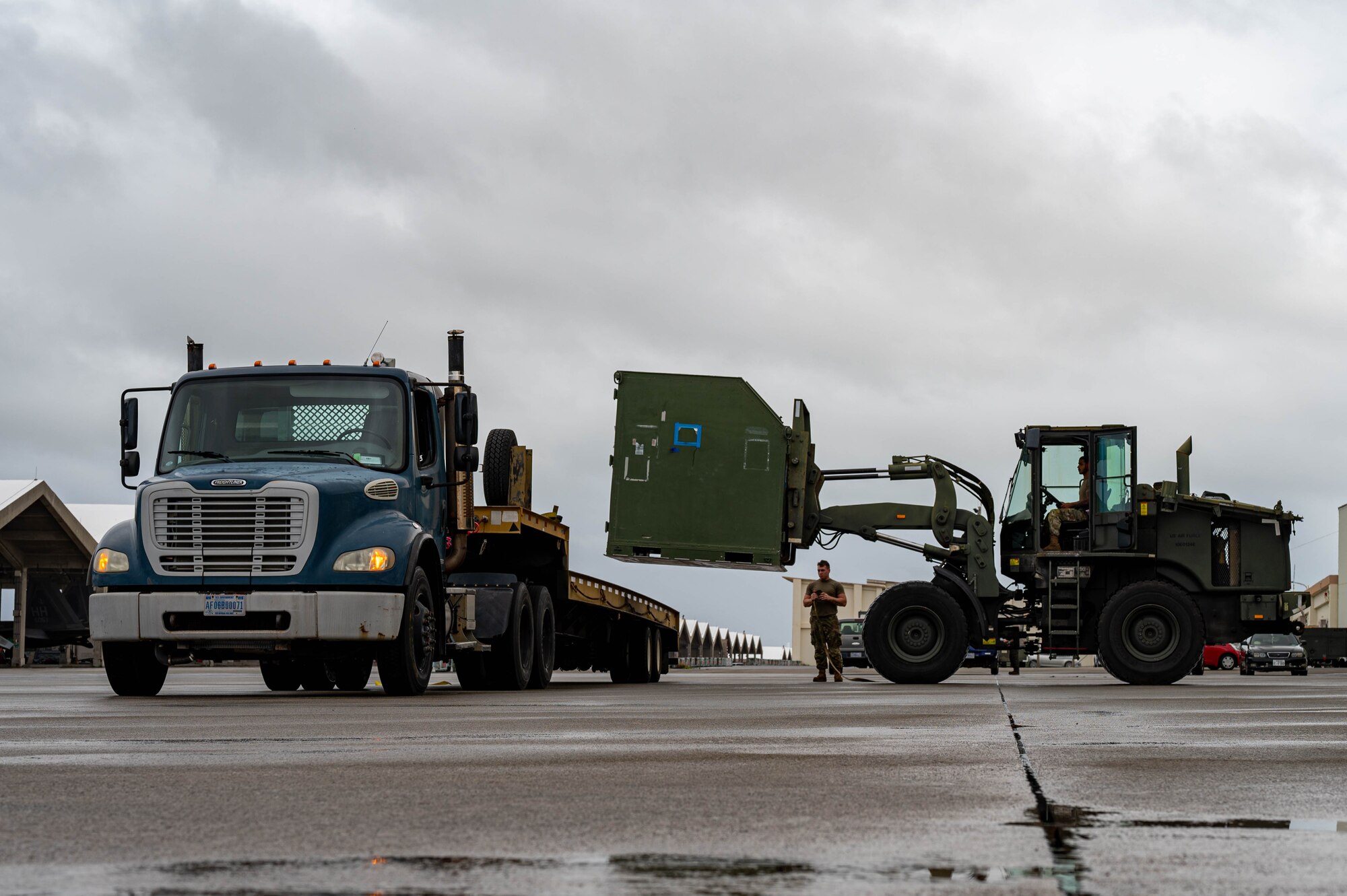 A forklift removes a cargo container from a truck to simulate equipment being offloaded from a cargo aircraft during an agile combat employment exercise, Shogun Shield, at Kadena Air Base, Japan, Sept. 18, 2024