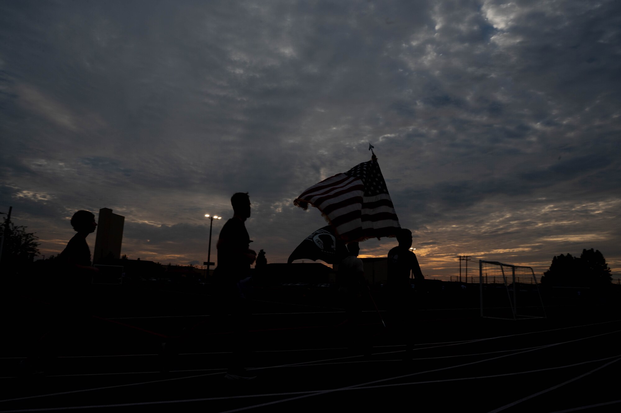 U.S. Air Force Airmen assigned to the 51st Fighter Wing run on a track carrying the U.S. and POW/MIA flags at Osan Air Base, Republic of Korea, Sept. 19, 2024. There are more than 81,000 service members who are considered POW/MIA from various conflicts. (U.S. Air Force photo by Staff Sgt. Christopher Tam)