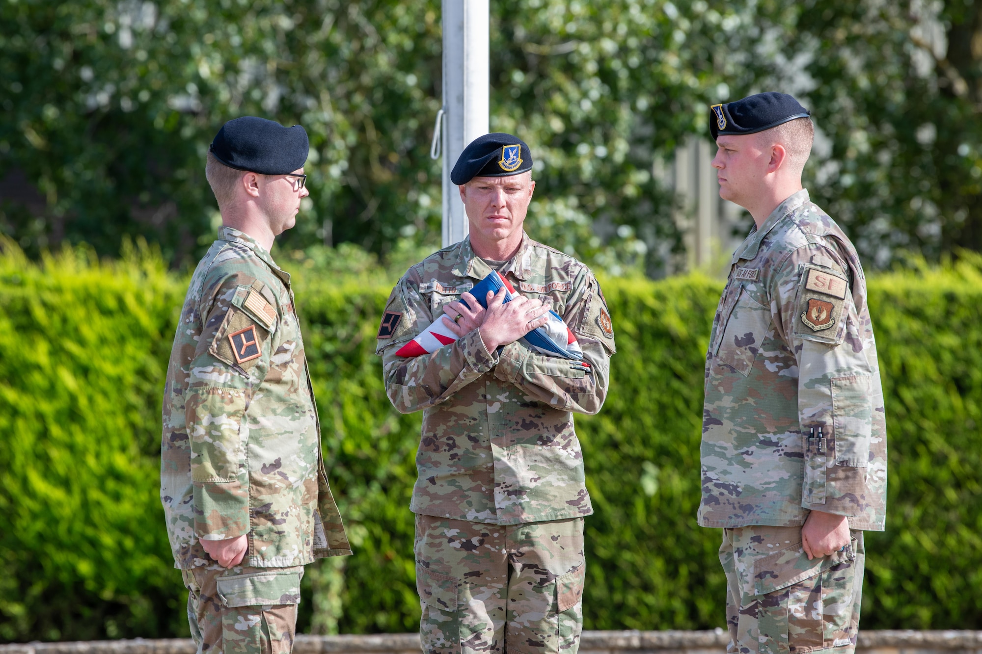 Airman holds a folded UK Royal Air Force Ensign during a retreat ceremony