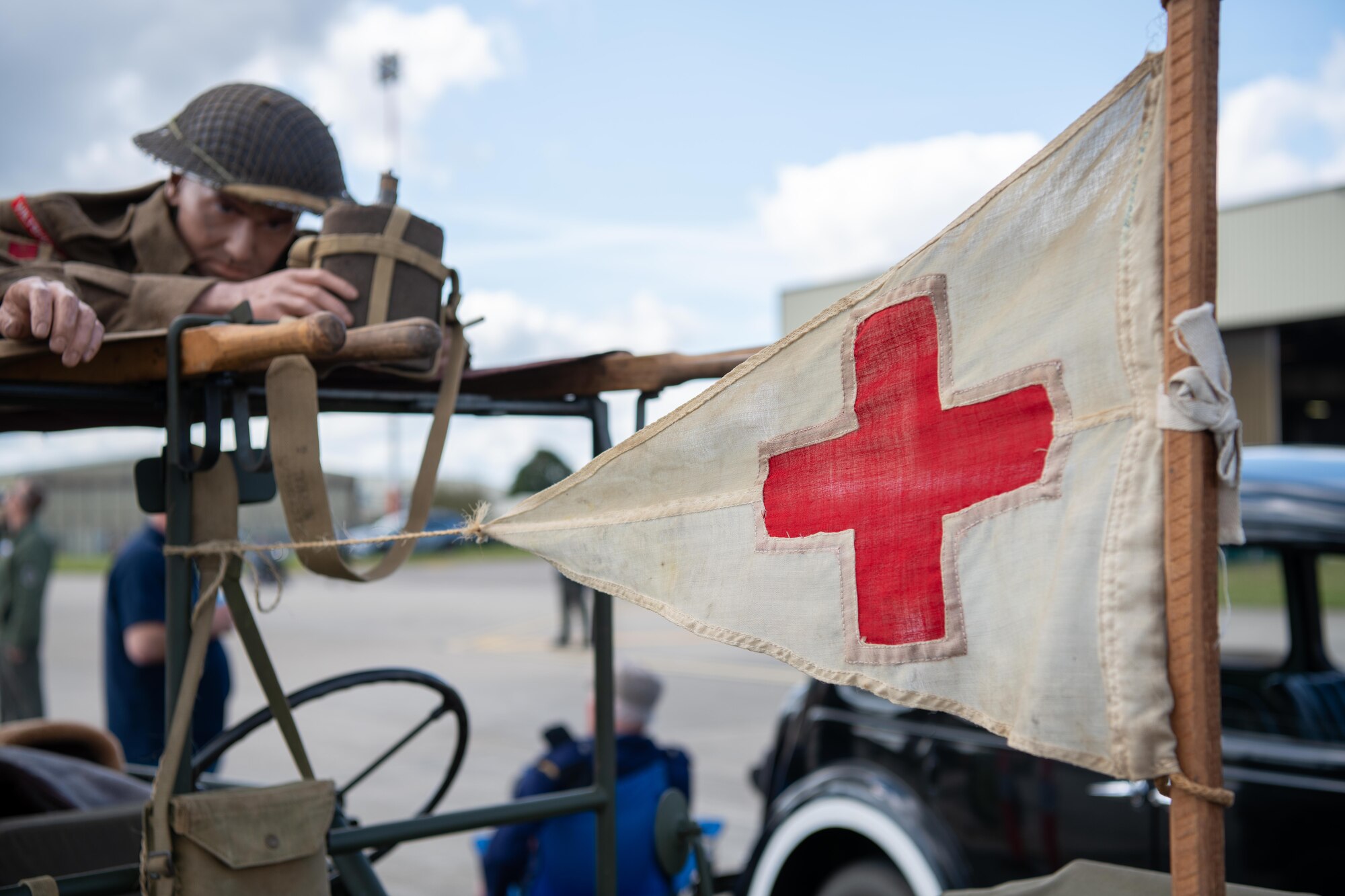 A red cross flag is displayed on a vintage vehicle during the RAF Fairford 80th Anniversary Heritage Day