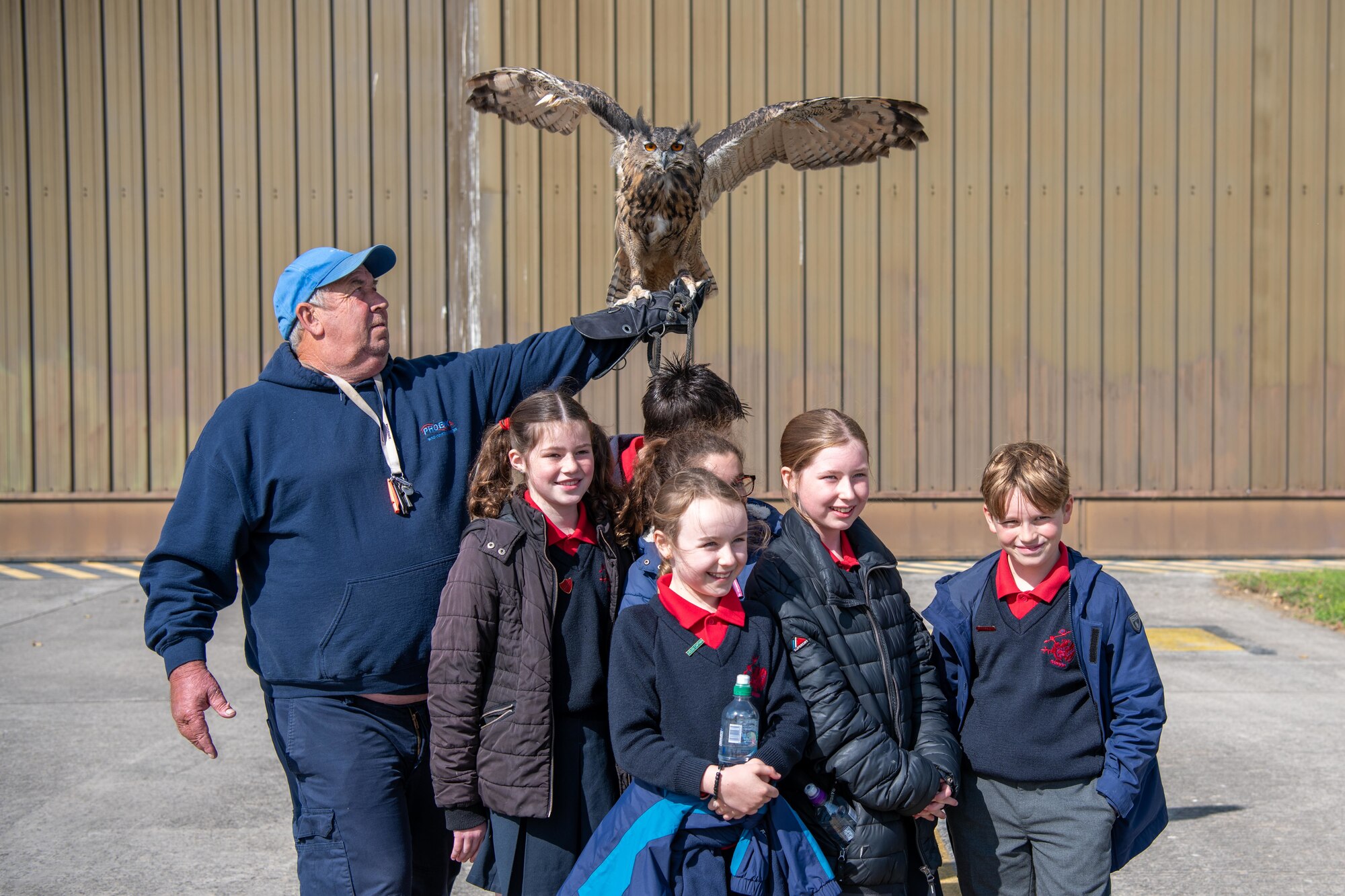 Kids pose for a group photo with an eagle-owl