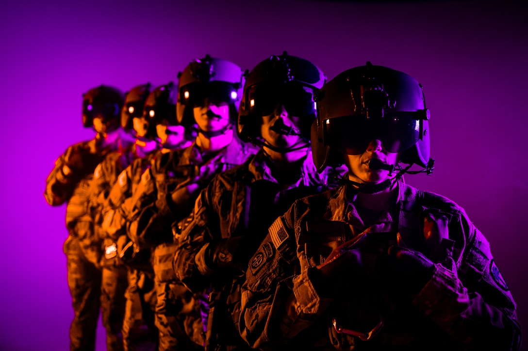 Six soldiers wearing helmets pose for a photo shoot against a purple background.