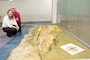 Two people crouch next to the 3D printed map