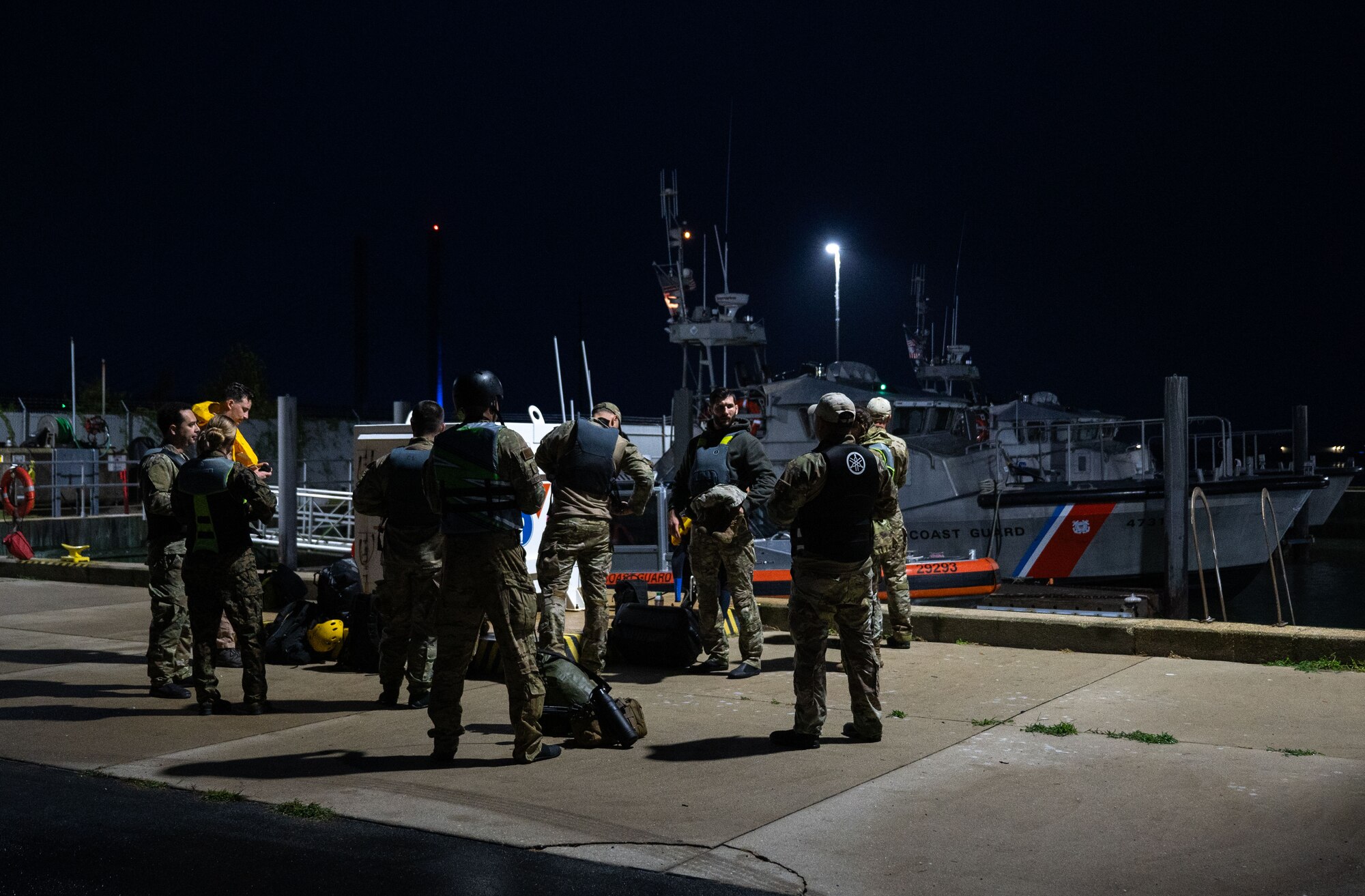 Team members for Exercise Castaway 24-4, consisting of U.S. Air Force, U.S. Marine Corps and U.S. Coast Guard, prepare their gear on the dock at U.S. Coast Guard Station Indian River Inlet, Rehoboth Beach, Delaware, Sept. 18, 2024. Castaway 24-4 was a total force interagency training exercise designed to test and execute search and rescue procedures. (U.S. Air Force photo by Airman Liberty Matthews)