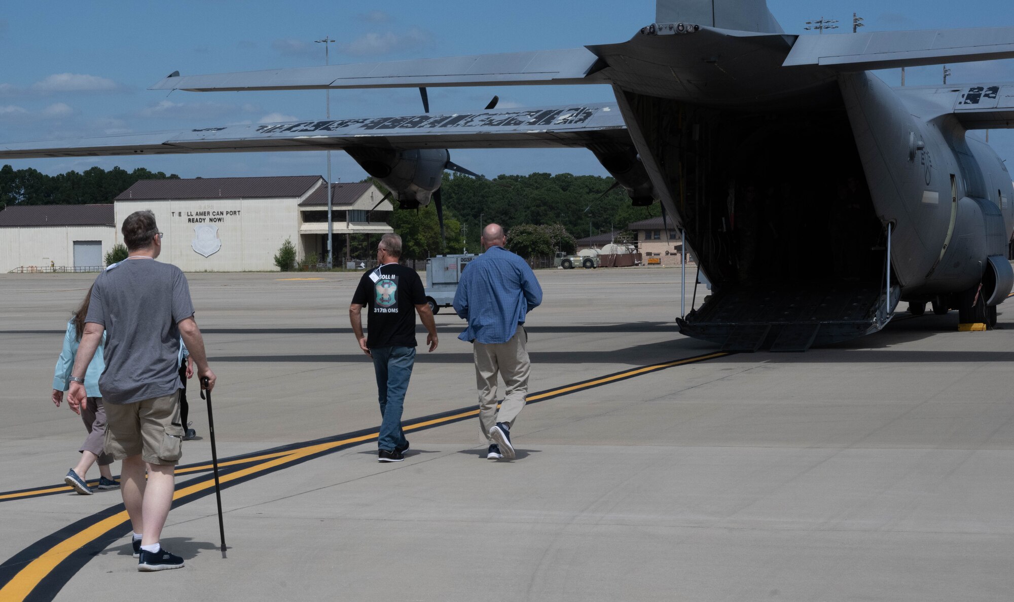 Veterans walk to a plane on the flight line.