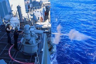 Gunner's mates fire a 25 mm machine gun system aboard USS Bulkeley (DDG 84).