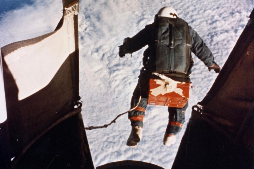 An astronaut jumps from a balloon at 102.800 feet toward Earth and the clouds.