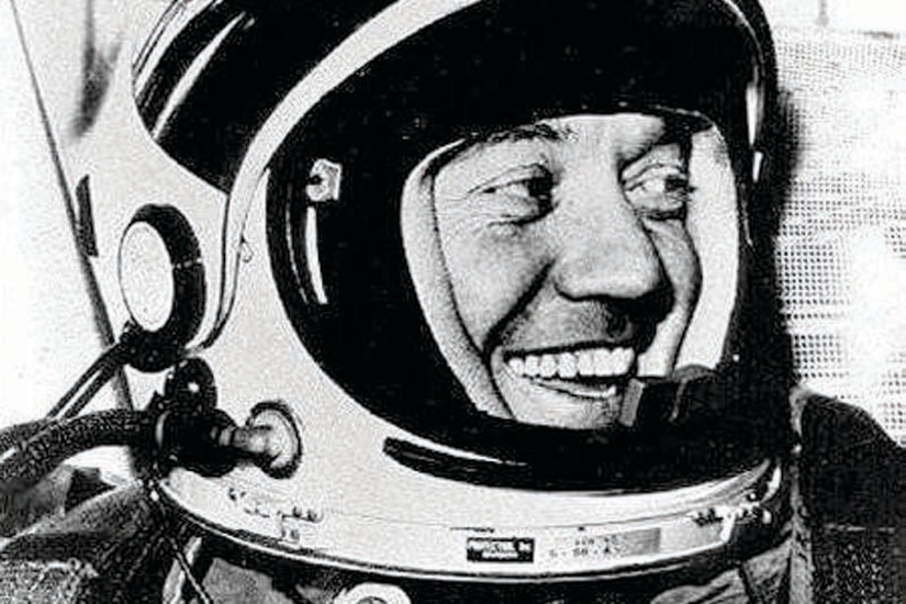 An astronaut with a helmet smiles.