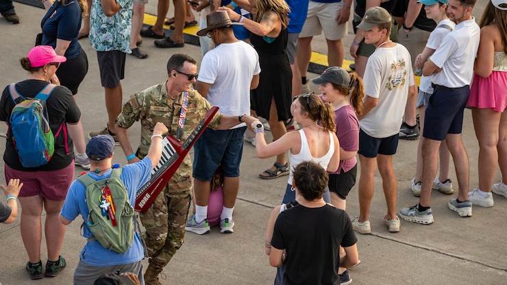 Shawn Hanlon fist-bumping an audience member while carrying his keytar.