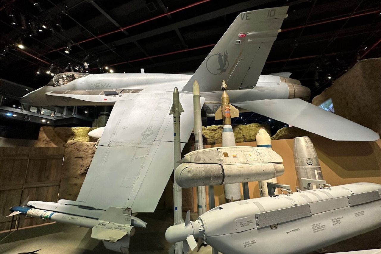 A jet and its defused ordnance are displayed inside a building.