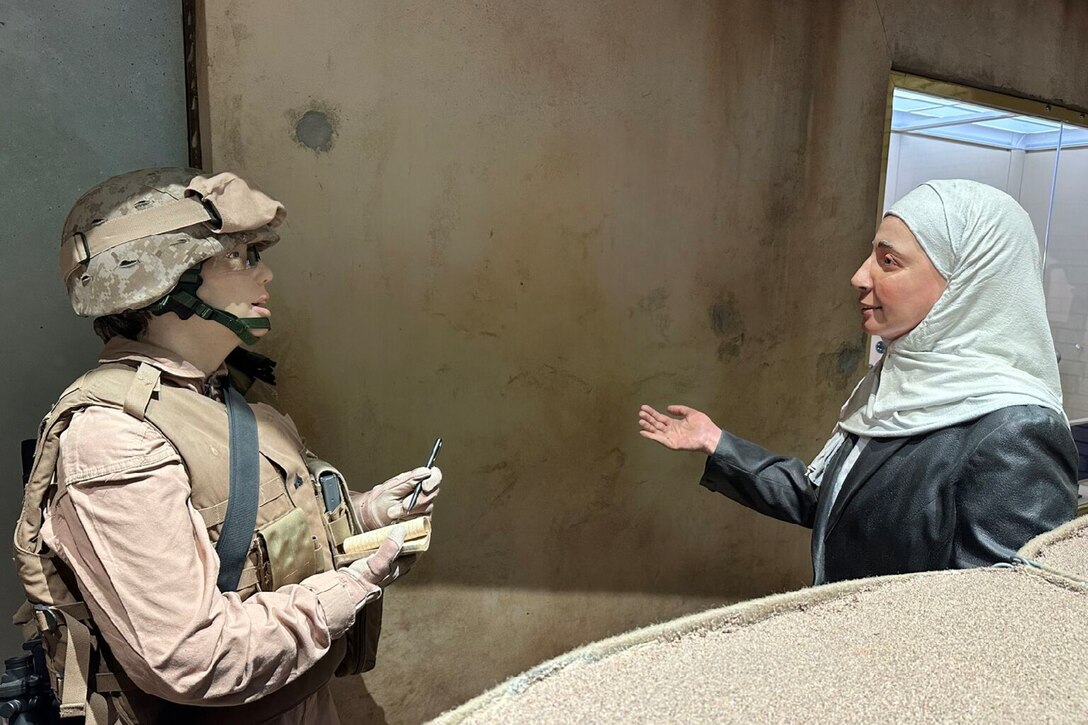 Mannequins dressed as a Marine and an Afghan woman are displayed in a museum exhibit.