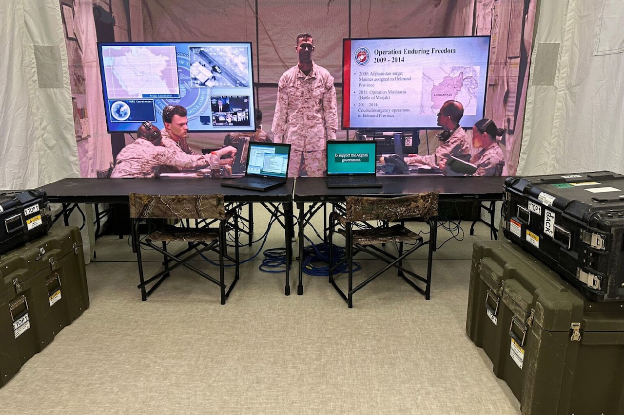 Mannequins dressed as Marines work on laptops inside a combat operation center in a museum exhibit.