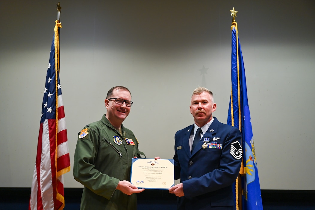 Col. Douglas Jeffrey, 433rd Airlift Wing commander, posed for a photo with Master Sgt. Raymond Johnson, a 433rd AES aeromedical evacuation technician, after presenting him the Distinguished Flying Cross with “C” device during a ceremony at Joint Base San Antonio-Lackland, Texas Sep. 12, 2024.