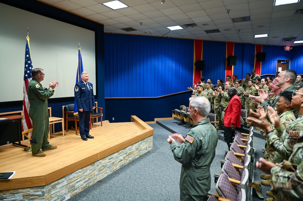 Col. Douglas Jeffrey, 433rd Airlift Wing commander, and fellow 433rd AW Reserve Citizen Airmen, give a standing ovation for Master Sgt. Raymond Johnson, a 433rd Aeromedical Evacuation Squadron aeromedical evacuation technician, after he received the Distinguished Flying Cross during a ceremony at Joint Base San Antonio-Lackland, Texas Sep. 12, 2024.