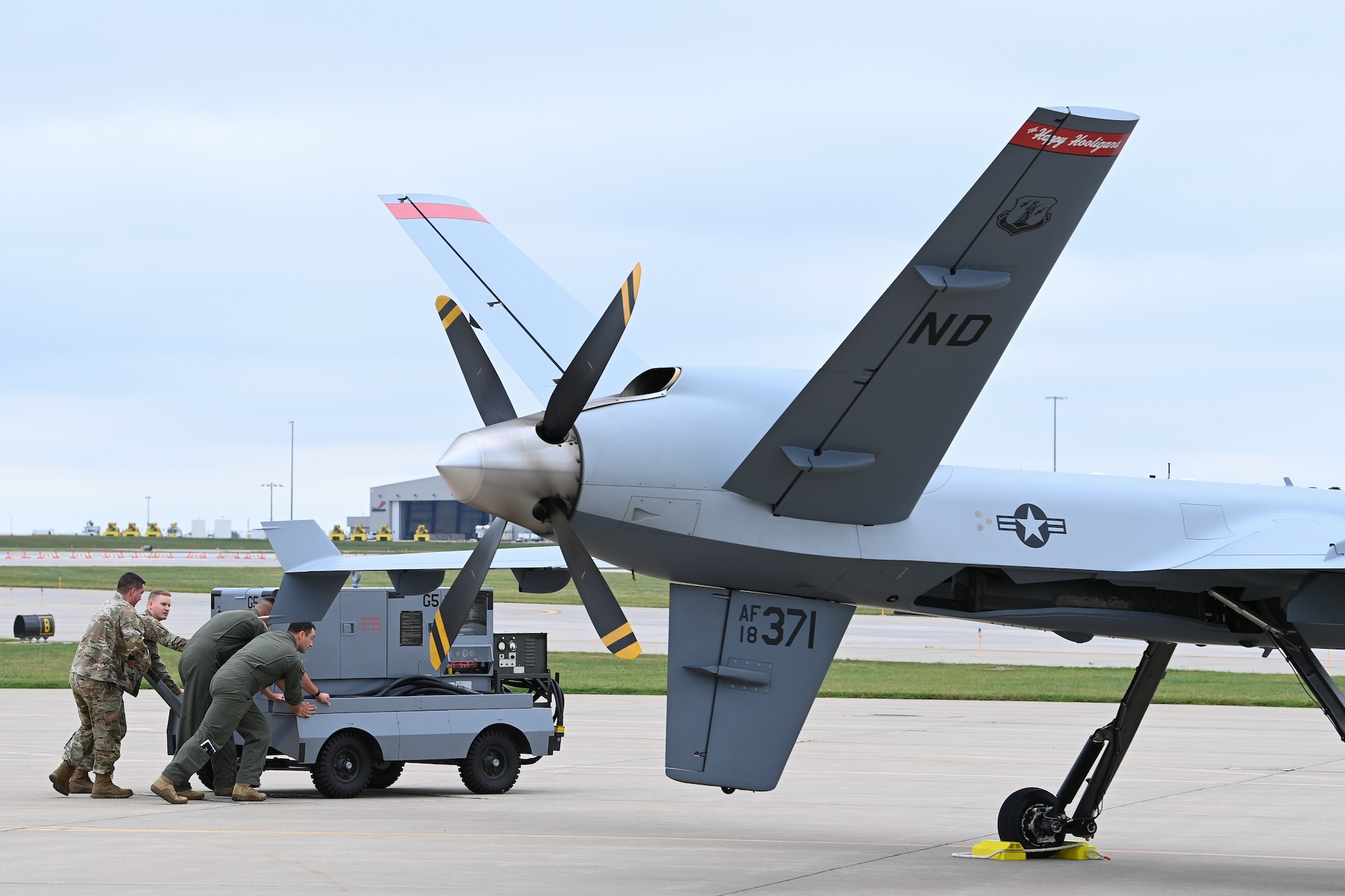 Airmen move generator on wheels next to aircraft