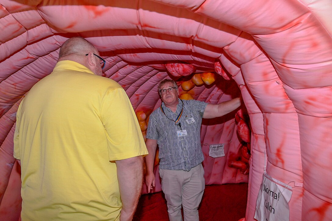 Two men standing in a pink tunnel