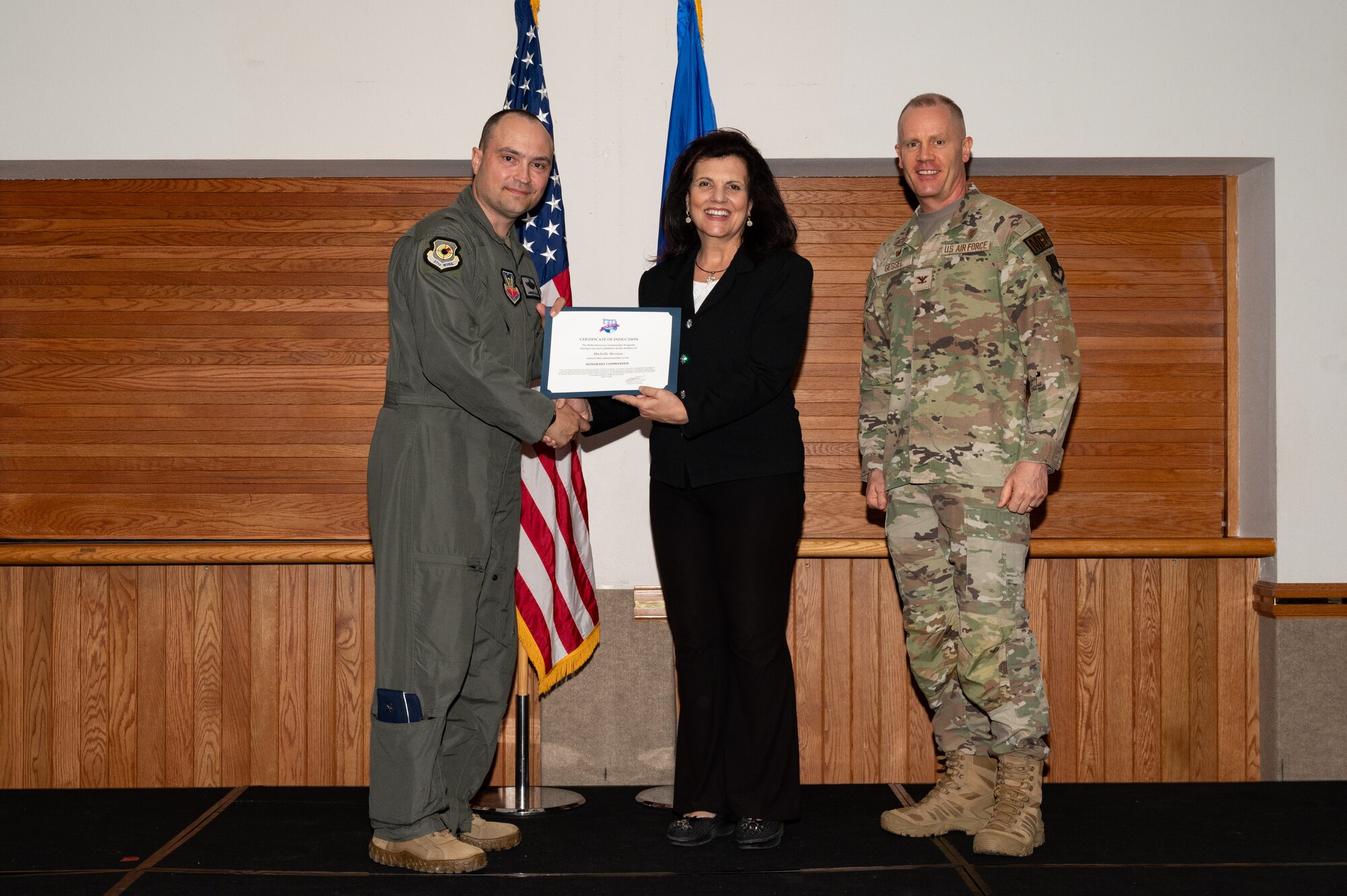 Two men and a woman posing for a photo