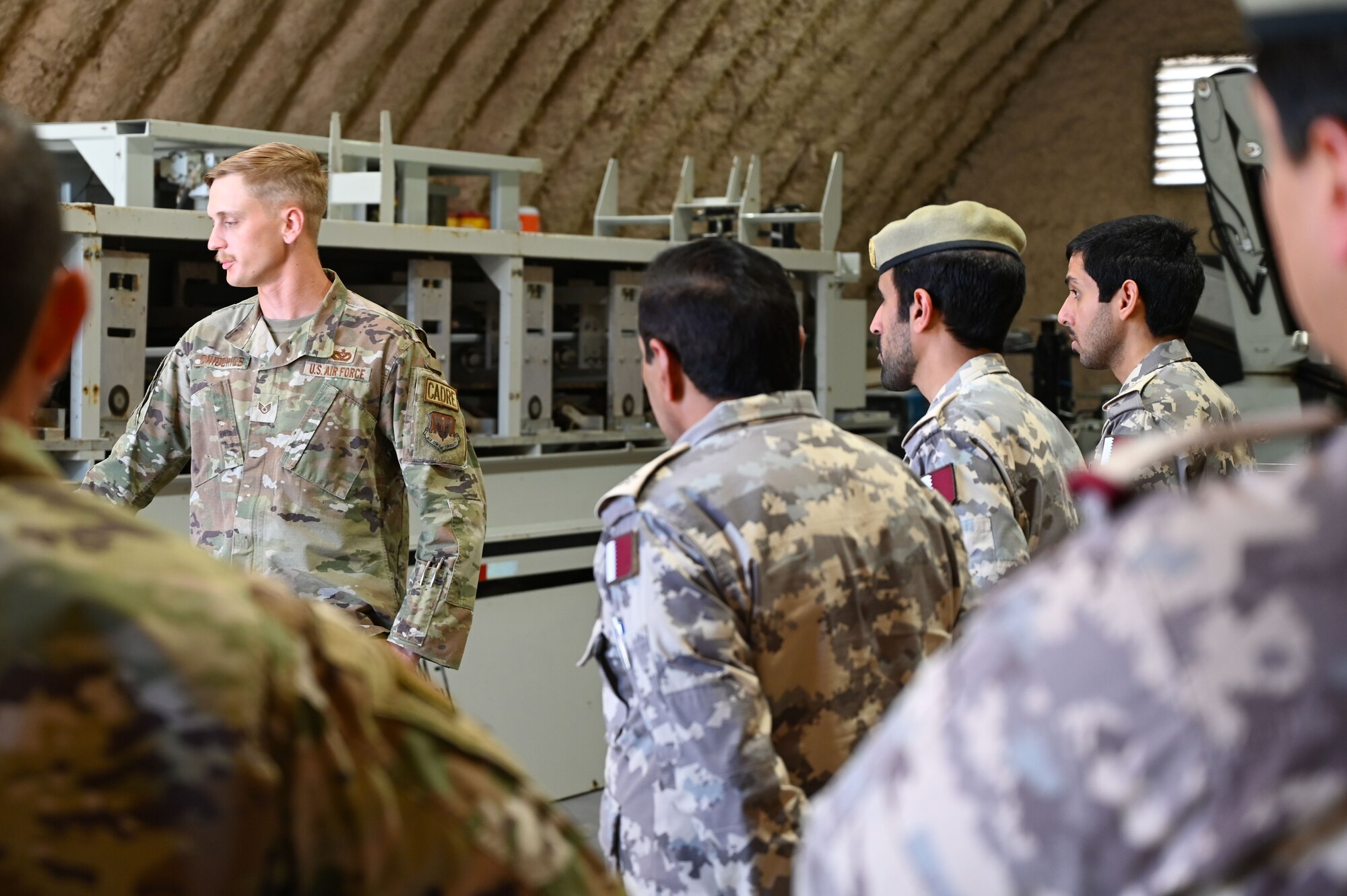 A U.S. Airman talks to the members of the Qatar Emiri Corps of Engineers