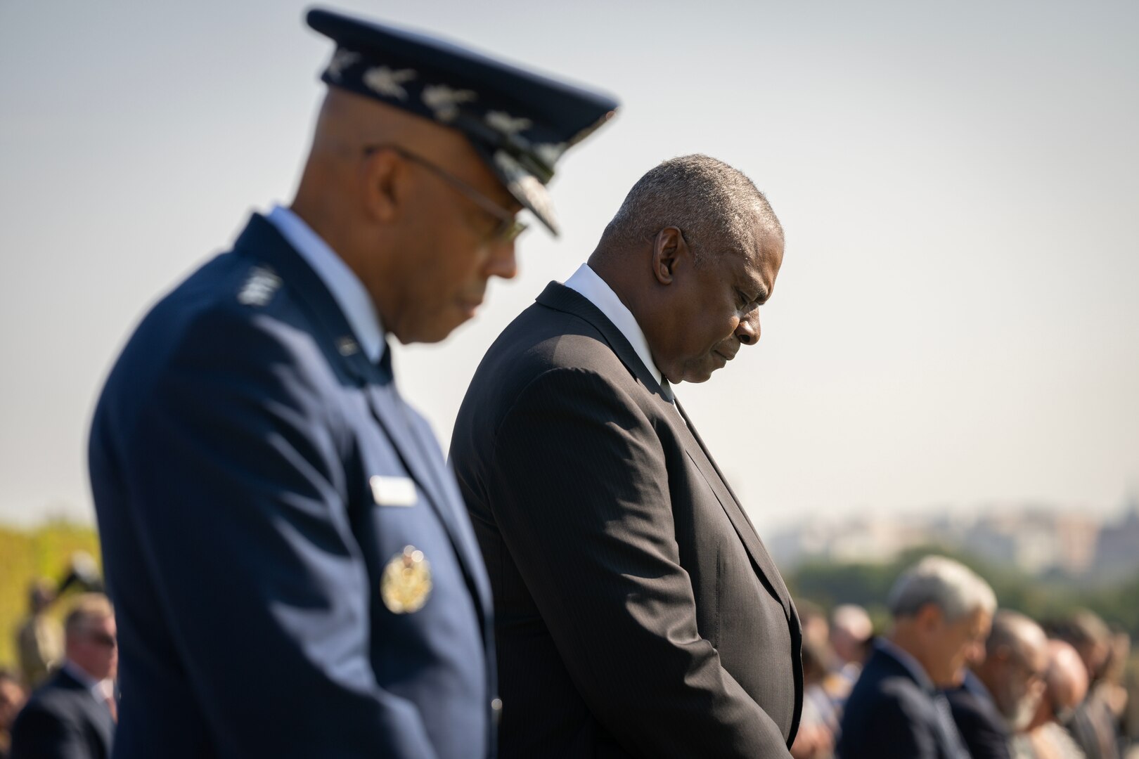 Two men close their eyes and bow their heads during a prayer.