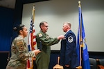 Master Sgt. Jeanett Vielman, 433rd Aeromedical Evacuation Squadron first sergeant, and Col. Douglas Jeffrey, 433rd Airlift Wing commander, present the Distinguished Flying Cross to Master Sgt. Raymond Johnson, a 433rd AES aeromedical evacuation technician, during a ceremony at Joint Base San Antonio-Lackland, Texas Sep. 12, 2024.