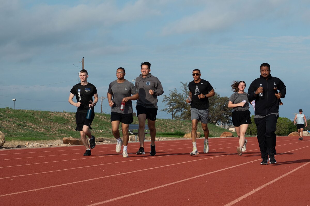 U.S. Space Force Guardians carry the POW/MIA baton during the POW/MIA 24-Hour Run and Name Reading at the Mathis Fitness Center outdoor track at Goodfellow Air Force Base, Texas, Sept. 19, 2024. The baton holds the names of all the service members who were Prisoners of War and still Missing in Action. (U.S. Air Force photo by Airman 1st Class Brian Lummus)