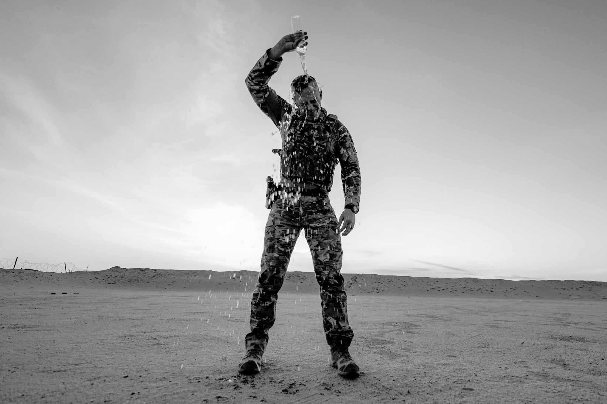 U.S. Air Force Master Sgt. Philip Sneed, 378th Expeditionary Security Forces Squadron operations superintendent, pours water on himself in preparation for a defender workout session at an undisclosed location within the U.S. Central Command area of responsibility, Aug. 6, 2024. During his first time as a flight chief and as a new senior noncommissioned officer, Sneed evolved his leadership style to a transformational technique so he could adequately care for each Airman. (U.S. Air Force photo by Senior Airman Ryan Hayman)
