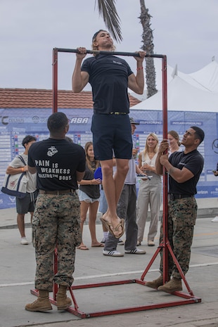 U.S. Marines from the Western Recruiting Region, hold the pull-up bar during the Super Girl Surf Pro competition at Oceanside Pier, Oceanside, California, Sept. 21, 2024. The Super Girl Surf Pro event is the only large-scale, all-women’s action sports, esports and lifestyle series in the world. The Marines participated in the event to support community relations and recruiting efforts. (U.S. Marine Corps photo by Cpl. Alexandra M. Earl)