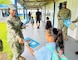 HAGAT, Guam (Aug. 15, 2024) - Seaman Yeoman Charanna McCall hands a folder to a student at the Marcial A. Sablan Elementary campus in Hågat on the first day of school, Aug. 15. McCall and other NBG Administrative Department staff handed out folders and pens. The folders were produced under Commander, Navy Installations Command in support of the NBG Listed Species and Marine Resources Outreach.