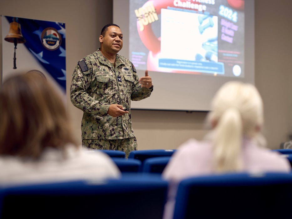 Capt. Torrin Velzquez, Commanding Officer, U.S. Naval Hospital Yokosuka, briefs upcoming medical program events to attendees at the CFAY 3rd Quarter Town Hall September 18, 2024.