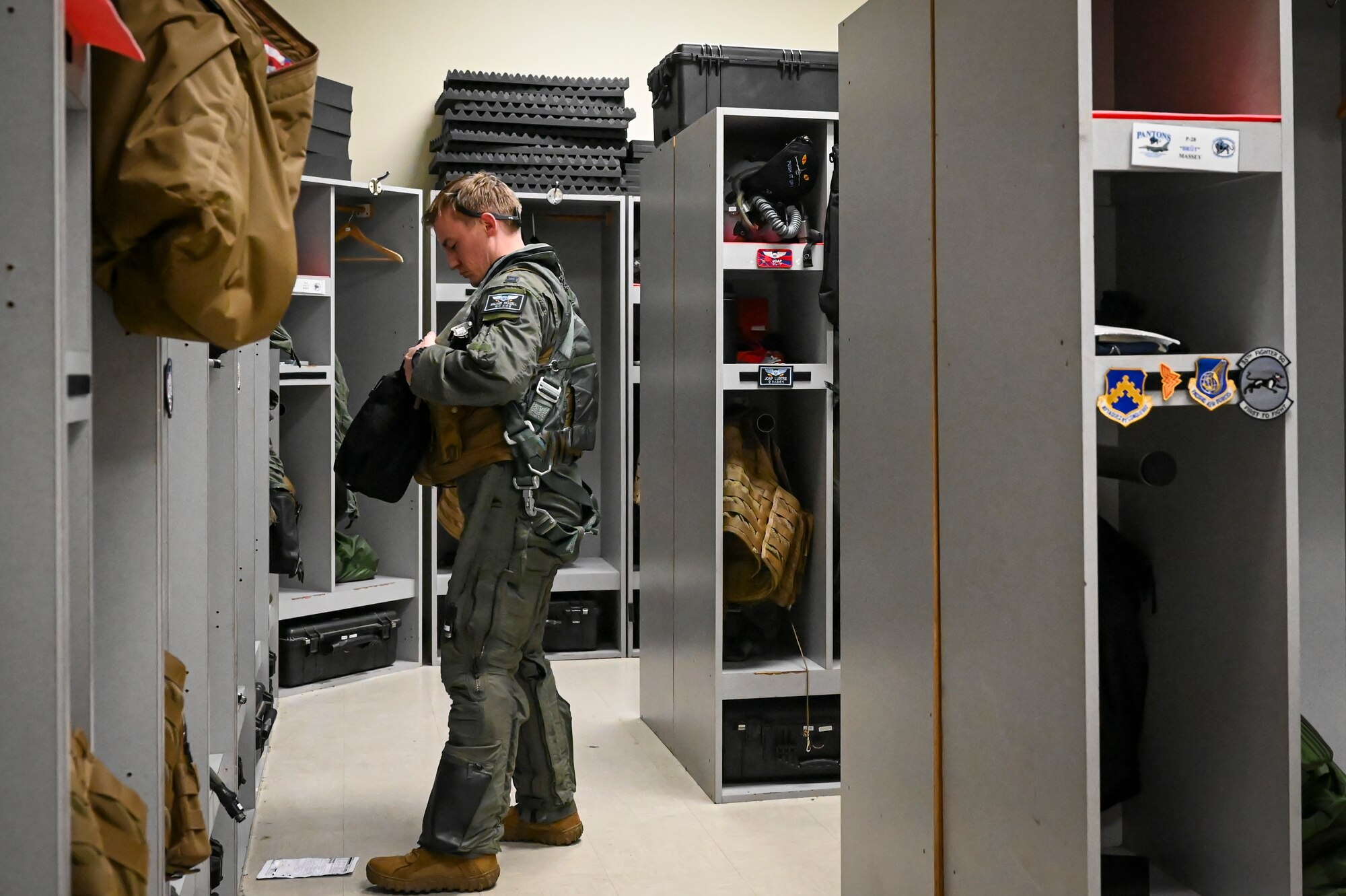 U.S. Air Force Capt. Walker Frazell, 35th Fighter Squadron F-16 Fighting Falcon pilot, prepares his aircrew flight equipment (AFE) in advance of conducting a training mission.