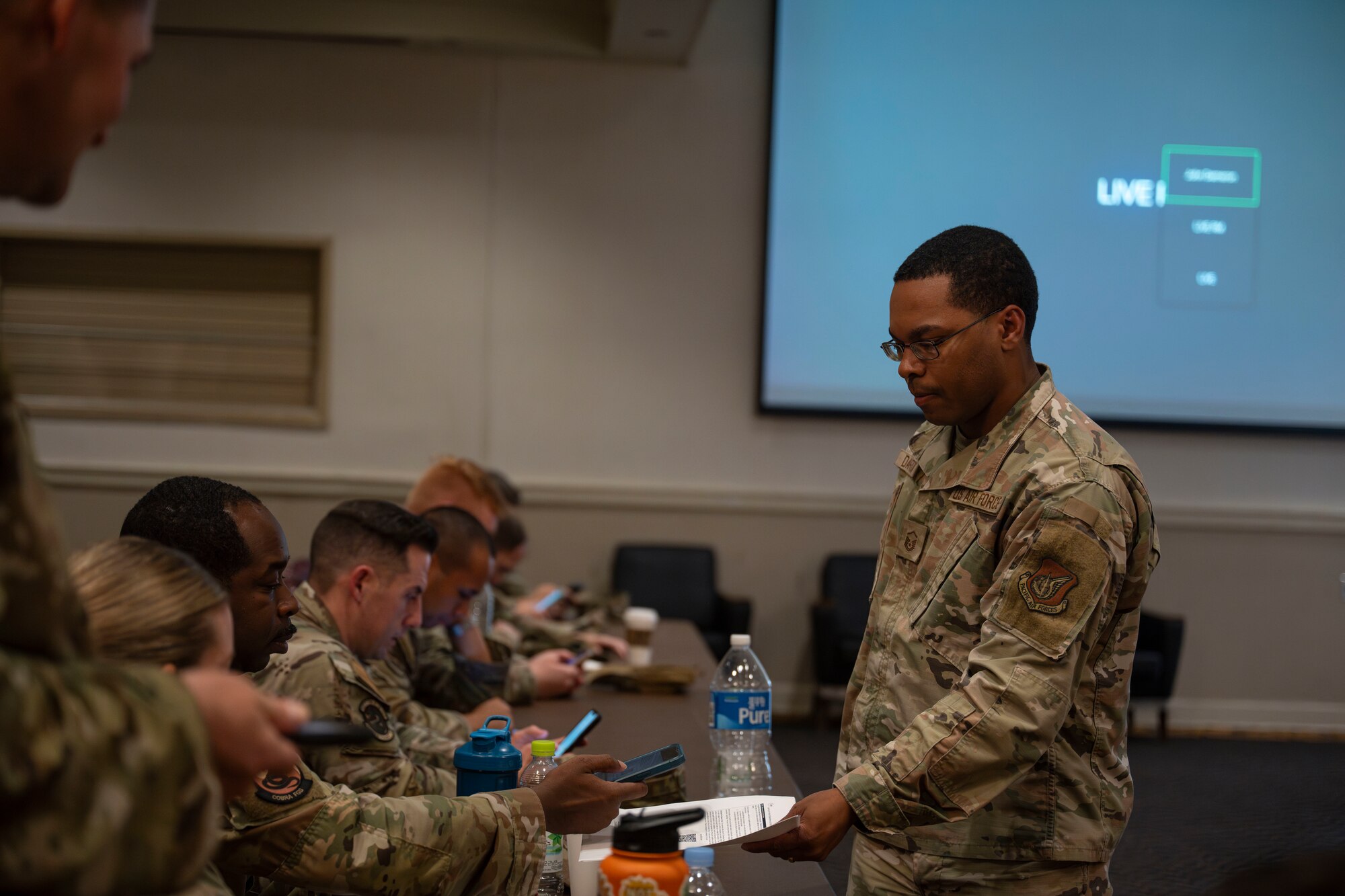 U.S. Air Force Master Sgt. John Dameron, 8th Fighter Wing Leaning In Virtual Experience program facilitator, passes around a QR code for a LIVE session during a senior noncommissioned officer professional education seminar at Kunsan Air Base, Republic of Korea