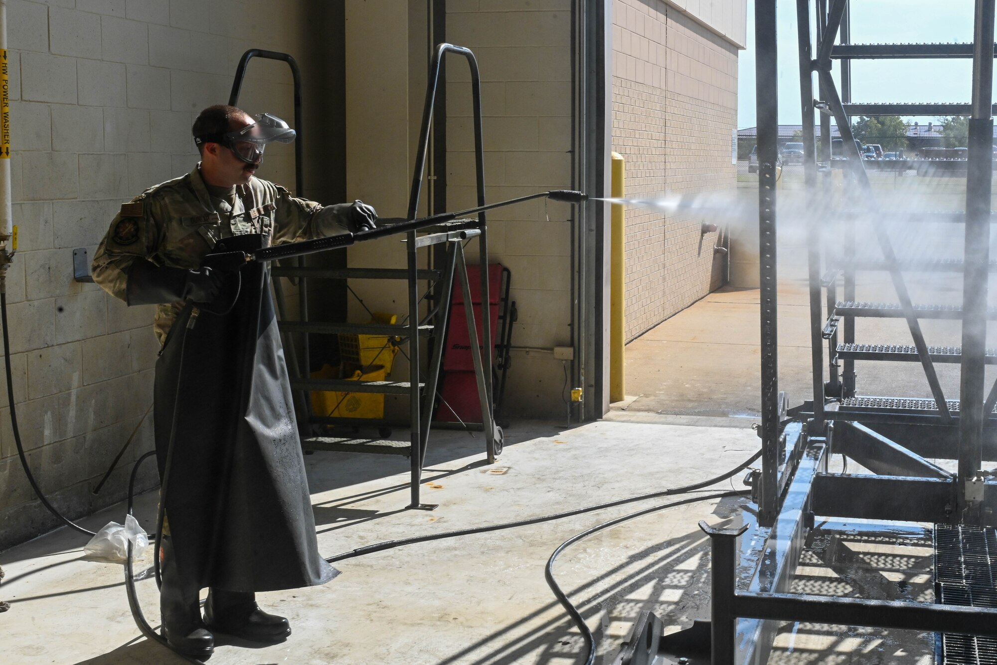 Airman Ethan Stephenson, 22nd Maintenance Squadron fuels apprentice, power washes a ladder Sept. 18, 2024, at McConnell Air Force Base, Kansas. The maintenance sections in the Air Force are responsible for ensuring aircraft and equipment are operational and conducting inspections and repairs to maintain readiness and safety for mission success. (U.S. Air Force photo by Senior Airman William Lunn)