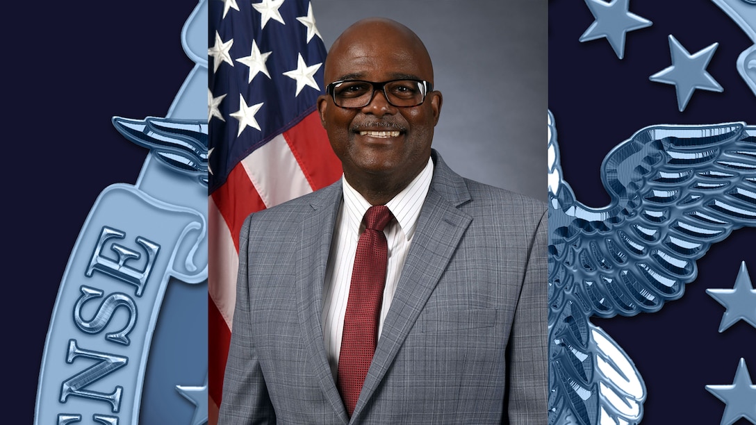 headshot of man in gray suit and maroon tie