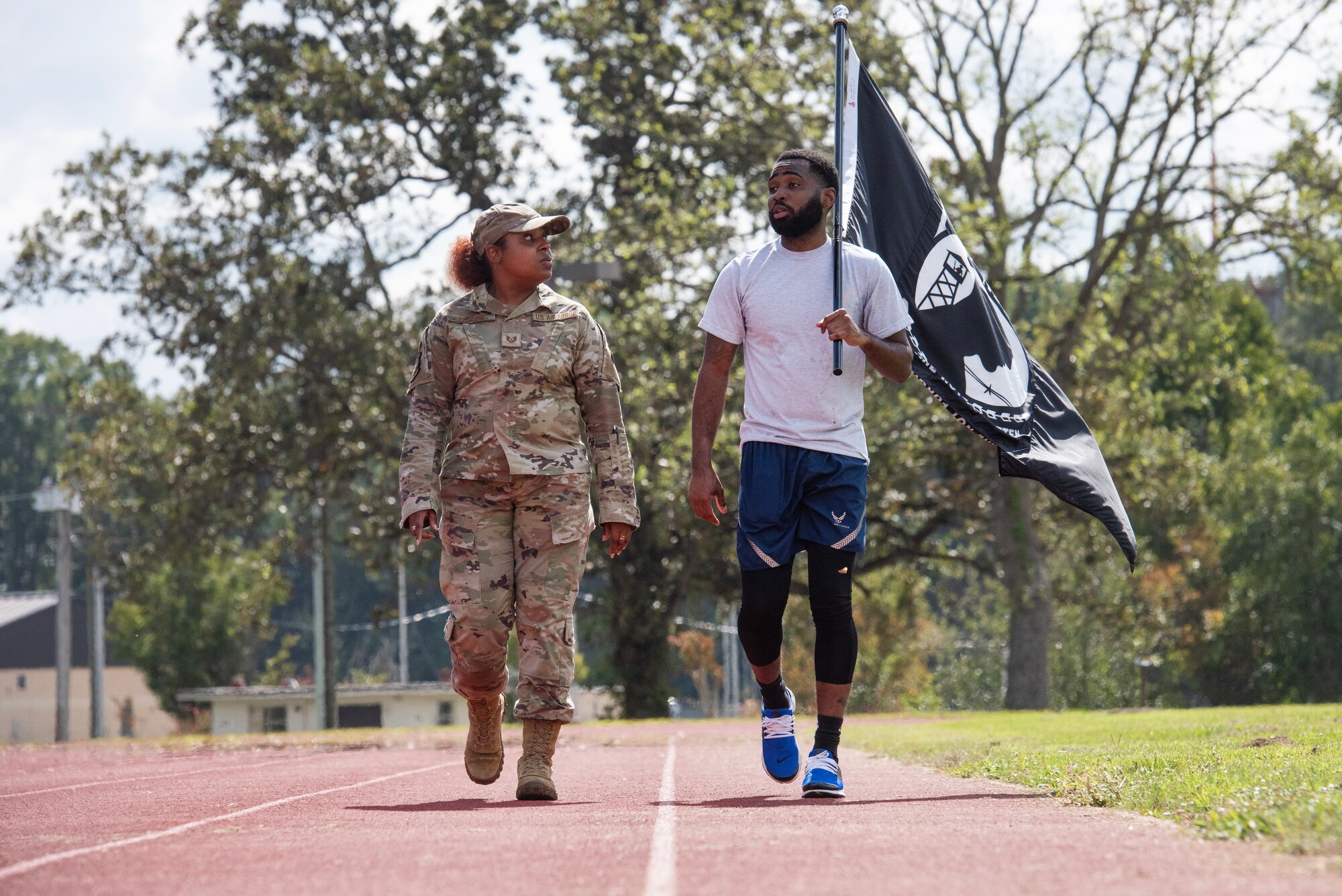 SSgt Tyvon Cooper and TSgt Taylor Brooks carry the POW/MIA Flag during a 24-hour vigil commemorating National POW/MIA Recognition Day.