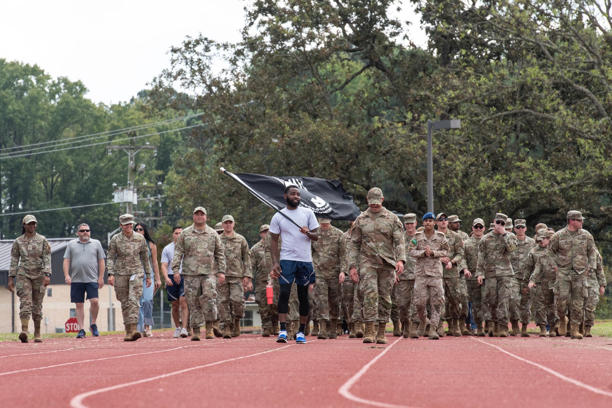 Service members and civilians help carry the POW/MIA Flag during a 24-hour vigil commemorating National POW/MIA Recognition Day.