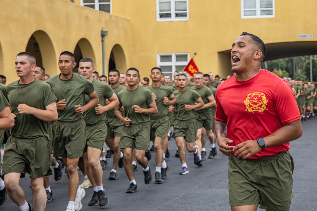 A Marine shouts as dozens of fellow recruits run in formation.