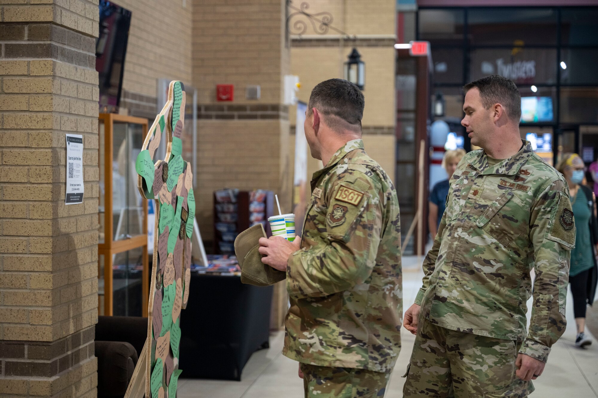 Senior Master Sgt. Joshua Hull, 22nd Aircraft Maintenance Squadron first sergeant, and Maj. Jamie Farris, 22nd AMXS commander, look at the Suicide Awareness Month exhibit at McConnell Air Force Base, Kansas, on Sept. 18, 2024. Members of Team McConnell were encouraged to write their “why” on wooden cutouts that are on display at the Robert J. Dole Center from Sept. 18-30. (U.S. Air Force photo by Senior Airman Felicia Przydzial)