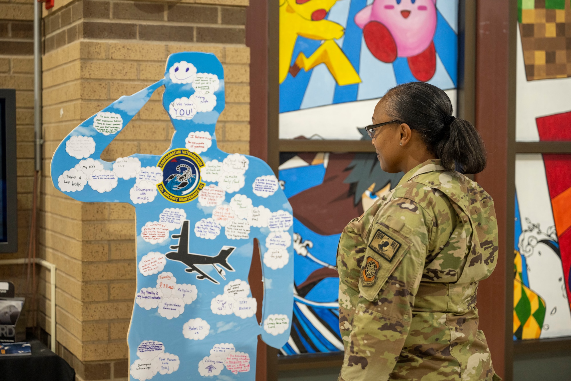 Master Sgt. Vandora Cooper, 22nd Air Refueling Wing Commander’s Action Group superintendent, looks at the wooden cutout from the 22nd Aircraft Maintenance Squadron at the Suicide Awareness Month exhibit on McConnell Air Force Base, Kansas, Sept. 18, 2024. Every squadron was given a wooden cutout for Airmen to write their “why” in support of Suicide Awareness Month. (U.S. Air Force photo by Senior Airman Felicia Przydzial)