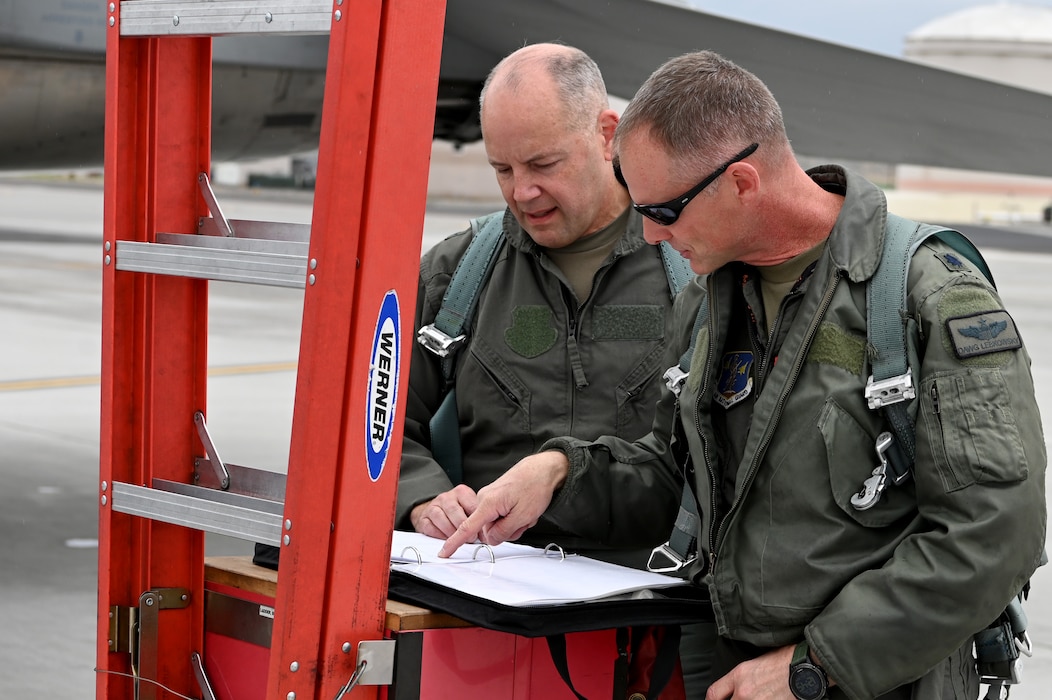 U.S. Air Force Maj. Gen. Duke Pirak, Deputy Director, Air National Guard, left, and Lt. Col. Quentin Lebkowsky, 173rd Fighter Wing F-15C instructor pilot, right, review the aircraft status paperwork before performing preflight ops checks.